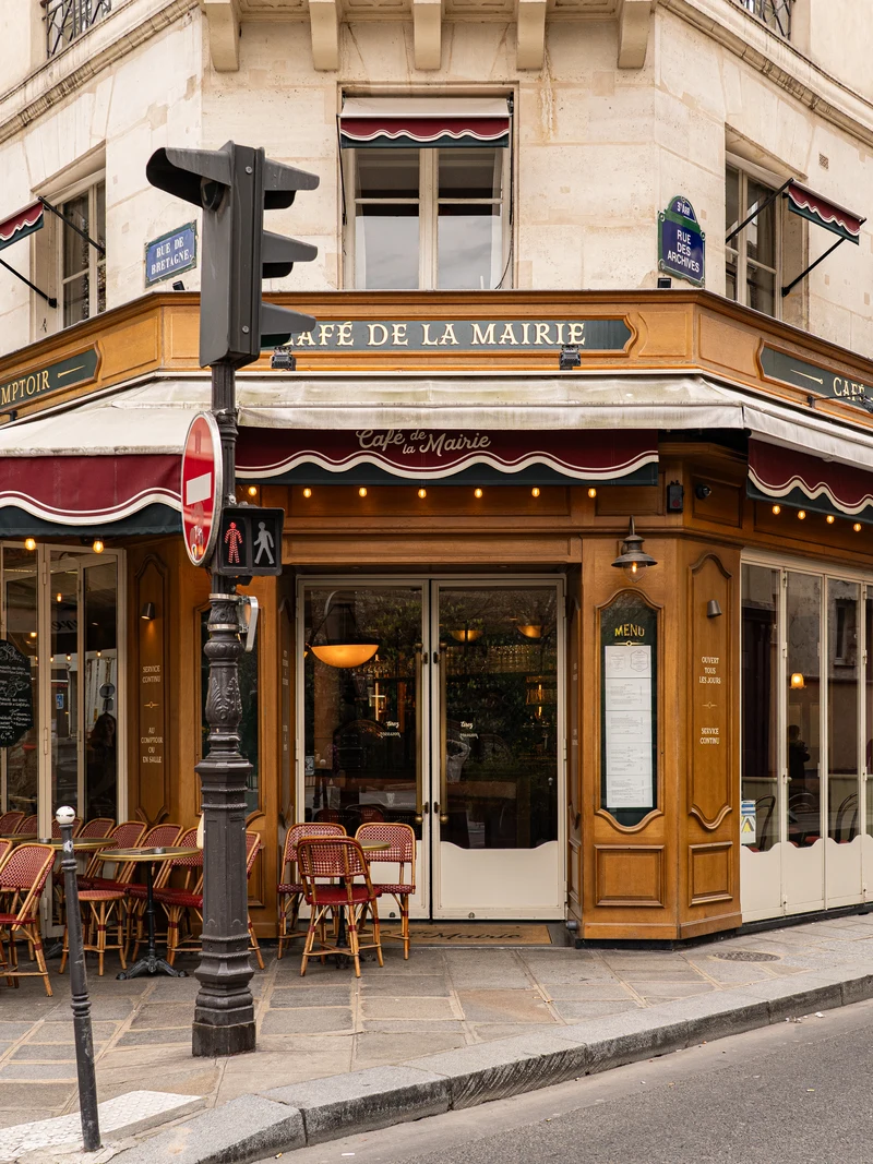 La patronne du Café de la Mairie devant la façade